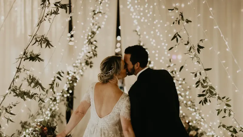 Wedding couple kissing under lights